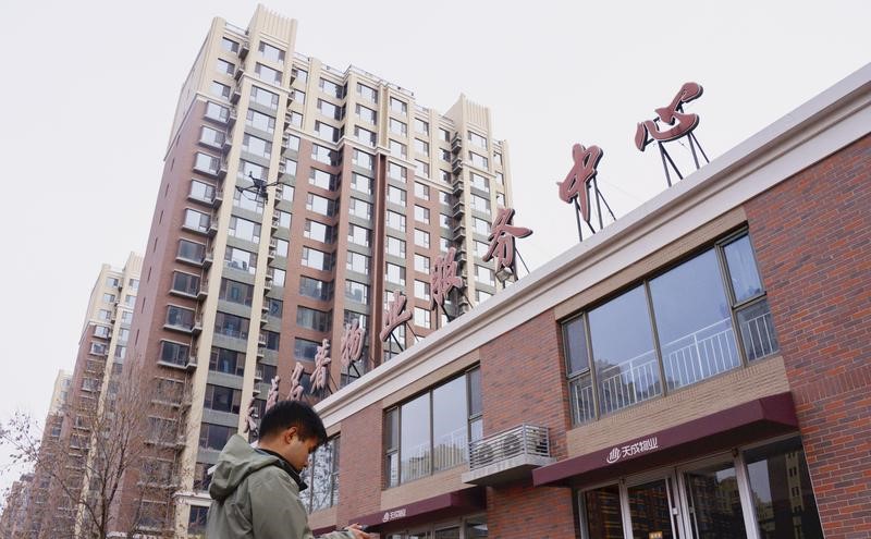工作人员正操控无人机对高楼外墙进行拍照。
